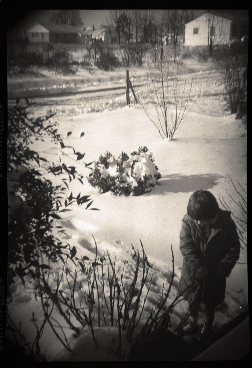 Photo of child in snow-covered yard, 1958.